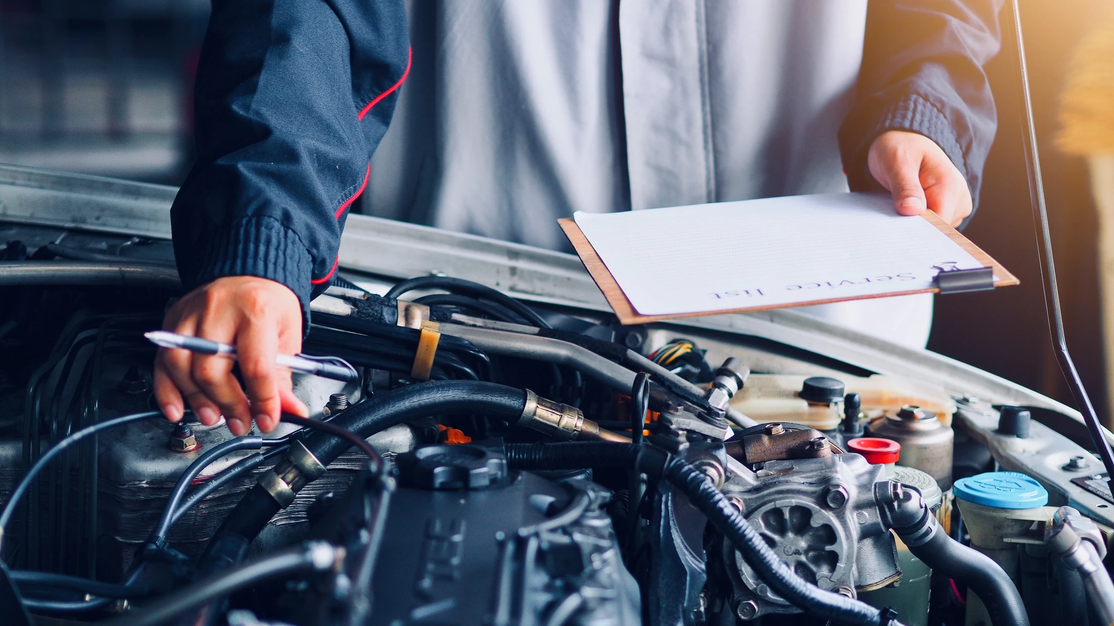Un mécanicien automobile inspecte un moteur à l'aide d'une caméra endoscopique connectée à un smartphone