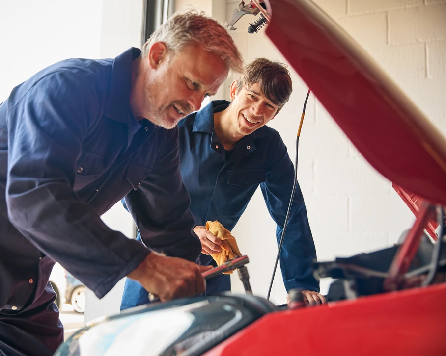 Une technicienne afro-américaine s'est concentrée pour vérifier la liste pour l'entretien dans le service de garage de voiture, portant l'uniforme de salle, l'air concentré en écrivant dans la tablette de documents